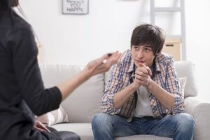 young man speaking with his therapist at a teen trauma treatment center