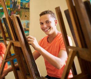 young teen male painting during art therapy for teens