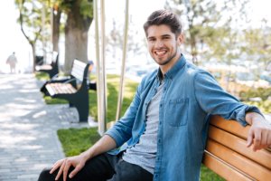 teen smiling on a bench because he found help with dialectical behavior therapy